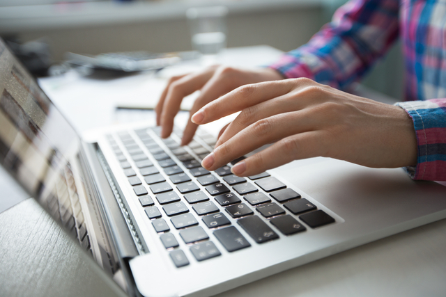 Cropped view of person hands typing on laptop computer