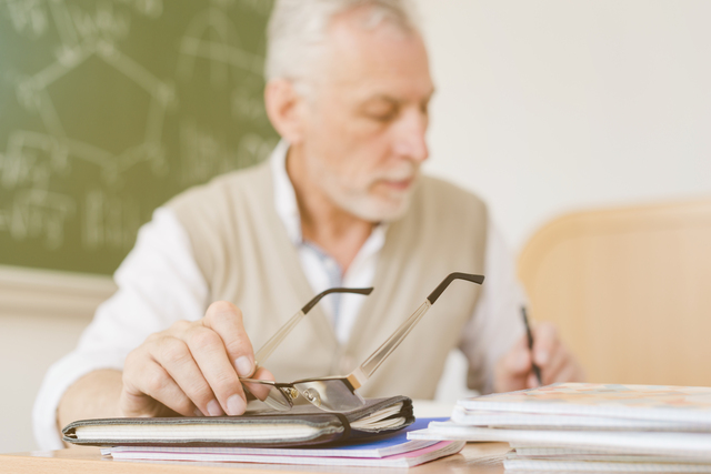 old professor making notes copybook