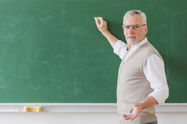 senior male professor explaining writing green chalkboard 1